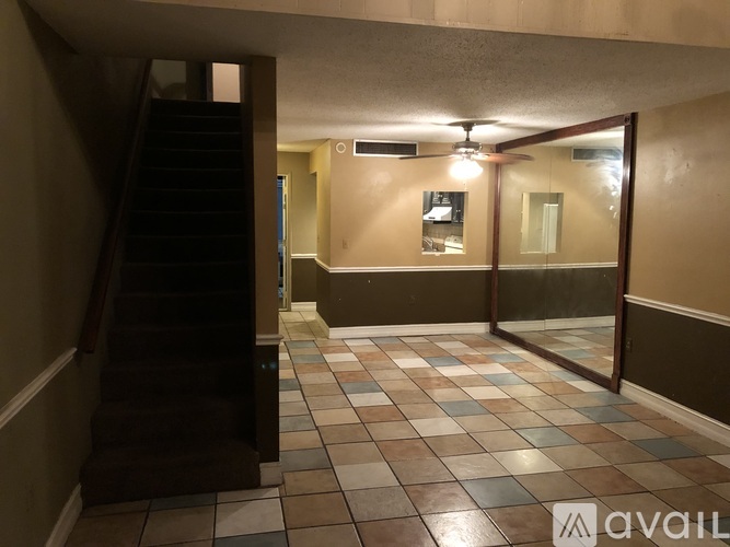 A hallway with a staircase on the left and a glass door on the right.