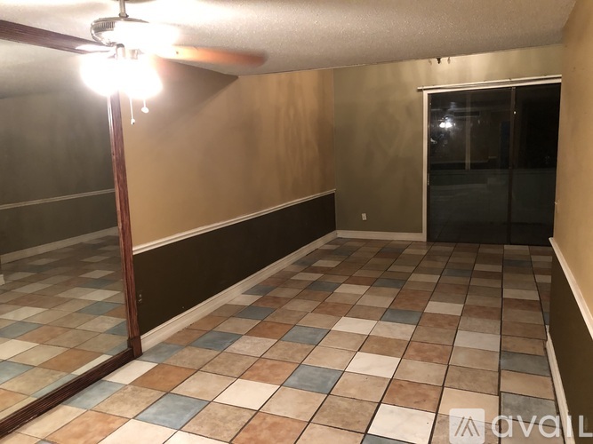 A room with a checkered floor and a ceiling fan.