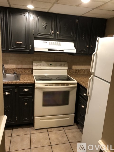 A kitchen with black cabinets and a white oven.