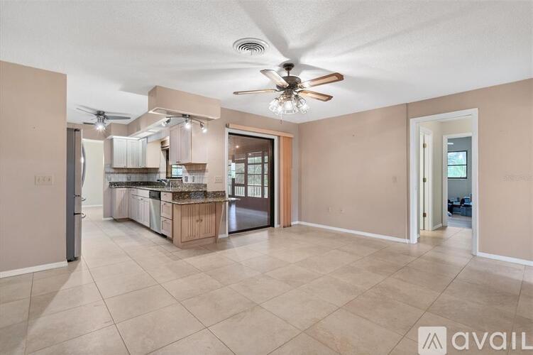 A kitchen with a refrigerator, sink, and cabinets is available for rent.