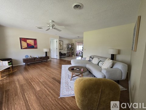 A living room with a white couch and a yellow chair.