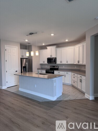 A modern kitchen with white cabinets and a central island.