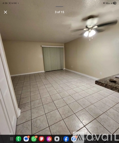 A room with a ceiling fan and tiled floor.