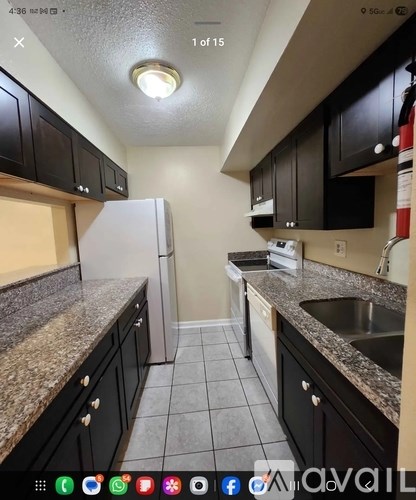 A kitchen with black cabinets and a granite countertop.
