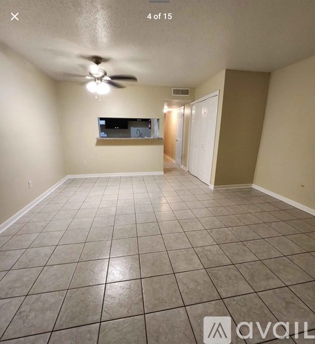 A room with a ceiling fan and a flat screen TV mounted on the wall.