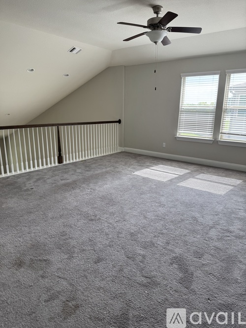 A room with a ceiling fan and a window with blinds.