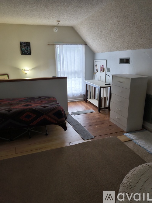 A bedroom with a bed, desk, and chair.