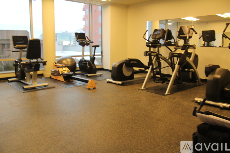 A gym with a variety of exercise equipment including treadmills, stationary bikes, and weight machines.