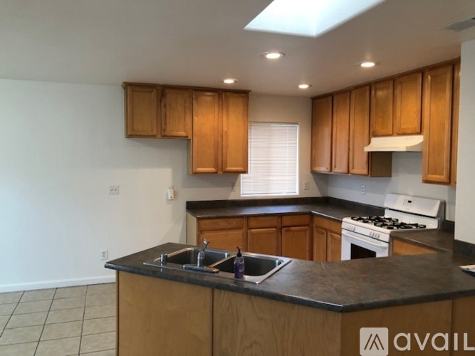 A kitchen with wooden cabinets and a black countertop.