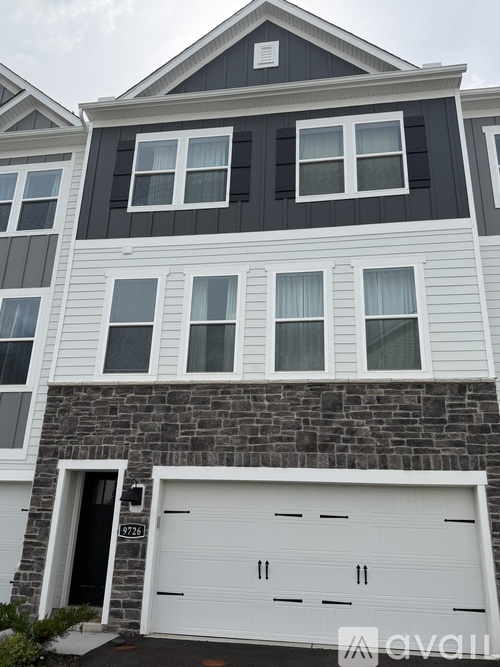 A two-story house with a white garage door.