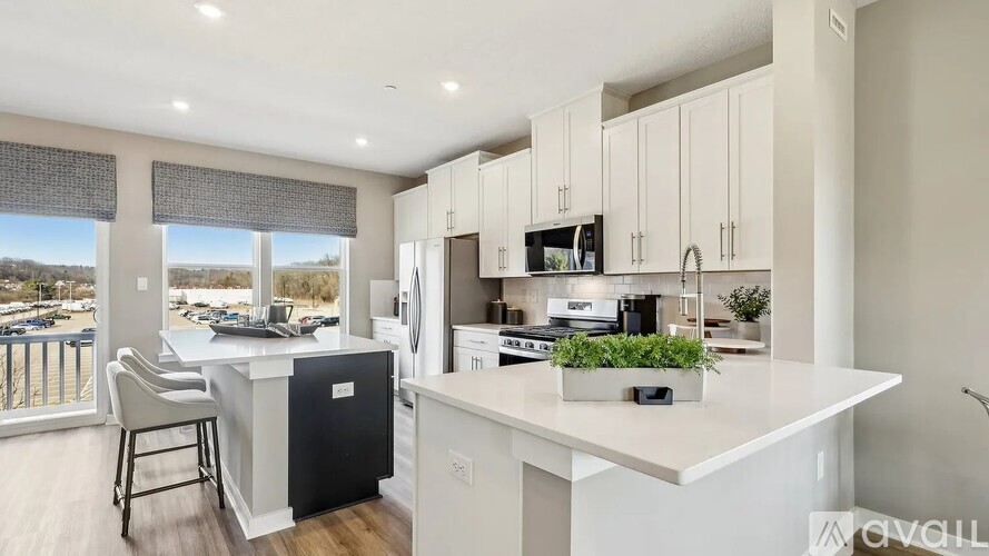 A modern kitchen with white cabinets and a large island.