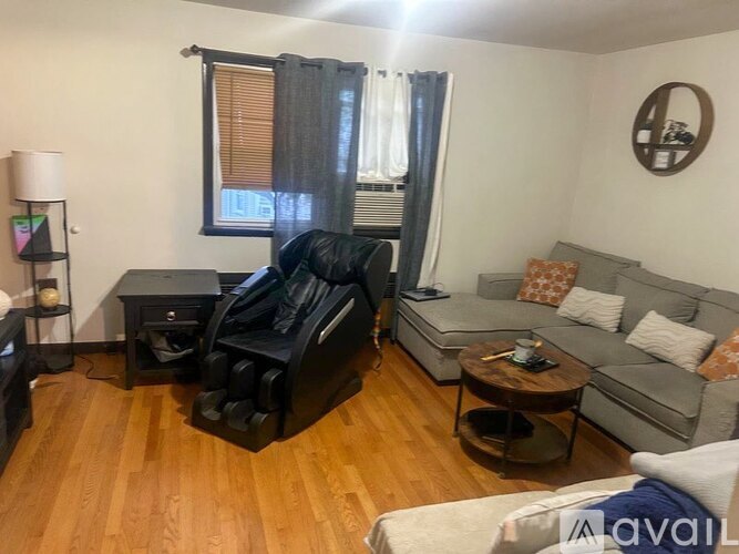 A living room with a black leather couch and a grey sofa.