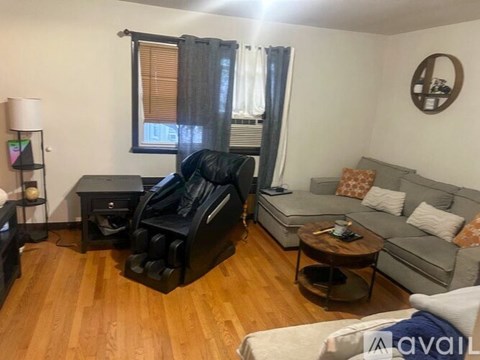 A living room with a black leather couch and a grey sofa.
