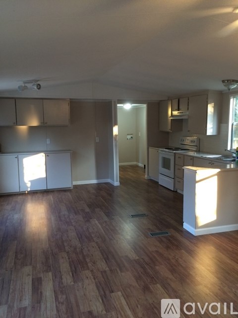 A kitchen with wooden floors and white appliances.
