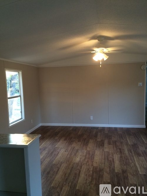 A room with wooden floors and a ceiling fan.