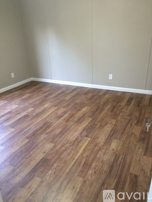 A room with wooden flooring and a key on the floor.