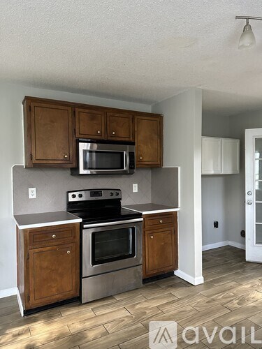A kitchen with wooden cabinets and stainless steel appliances.