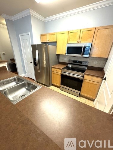 A kitchen with wooden cabinets and stainless steel appliances.
