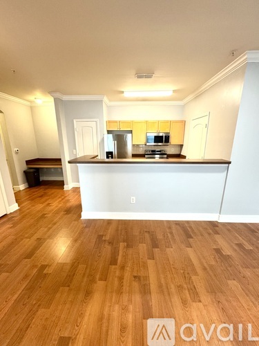 A kitchen with wooden floors and white walls.
