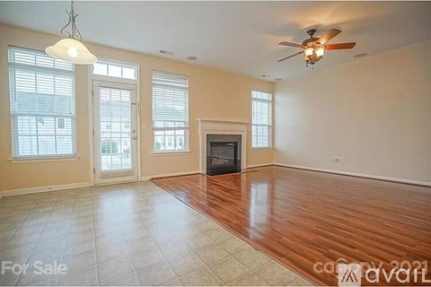 A living room with a fireplace and a fan.
