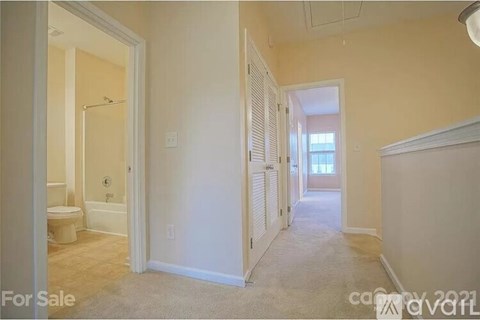 A room with a toilet and a bedroom with a window.