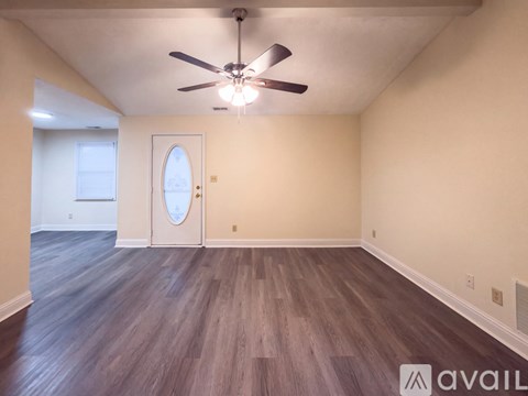 A room with a ceiling fan and carpeted floor.