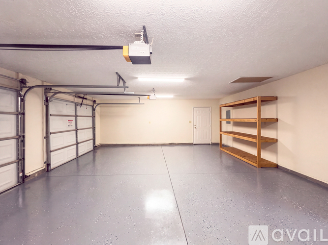 A spacious garage with a grey floor and white walls.