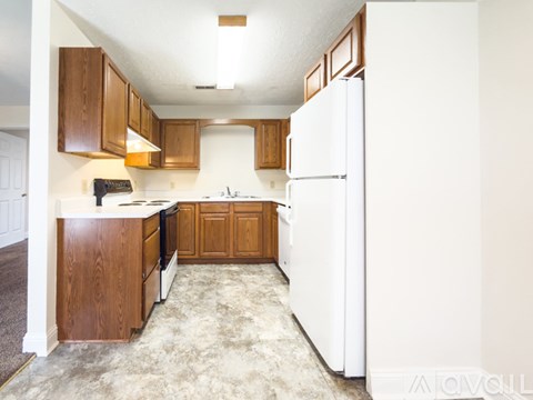 A kitchen with white appliances and wooden cabinets.