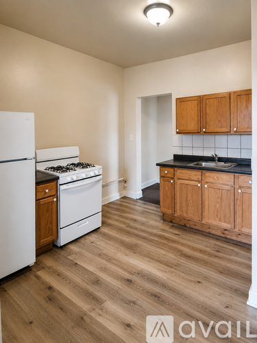 A kitchen with wooden cabinets and a white fridge.