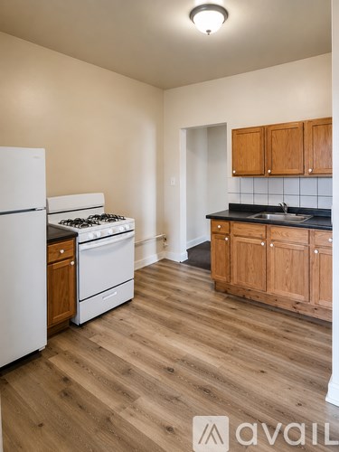 A kitchen with wooden cabinets and a white fridge.