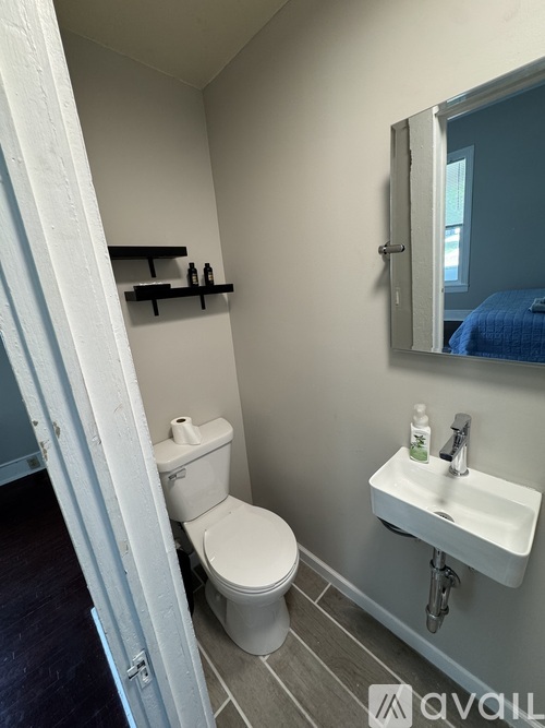 A white toilet sits next to a white sink in a small bathroom.