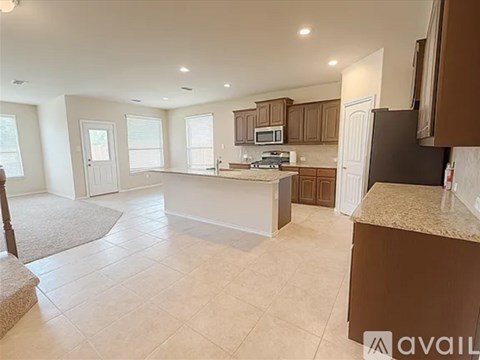 A kitchen with brown cabinets and a granite countertop.