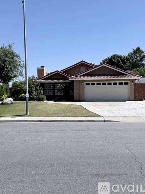 A house with a garage is situated on a street corner.