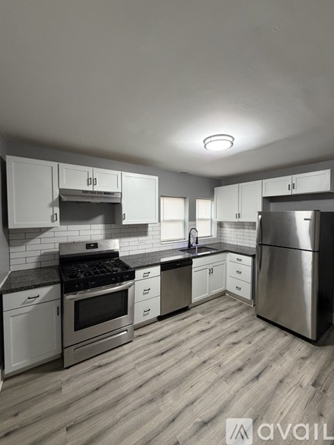 A modern kitchen with stainless steel appliances and white cabinets.