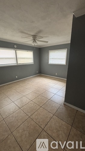 A room with a ceiling fan and tile flooring.