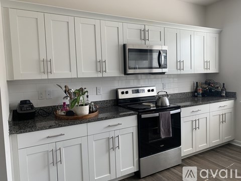 A kitchen with white cabinets and a black stove top oven.