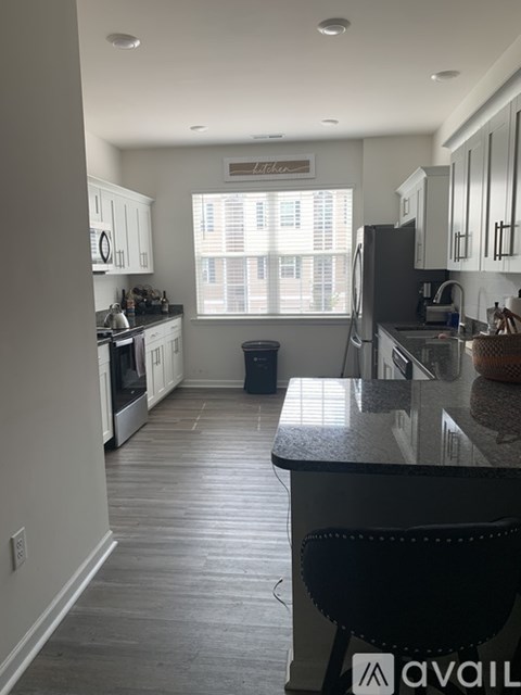 A kitchen with a black counter top and white cabinets.