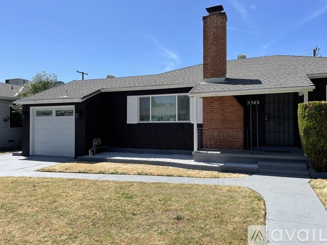 A house with a garage and a driveway in front.