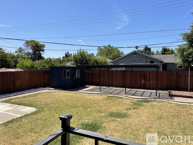 A backyard with a wooden fence and a shed.
