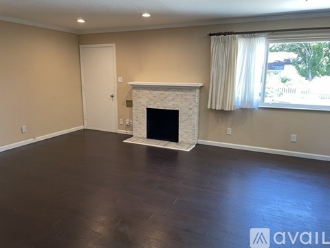 A living room with a fireplace and a window.