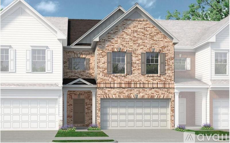 A two-story house with a brick facade and white garage doors.