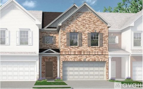 A two-story house with a brick facade and white garage doors.