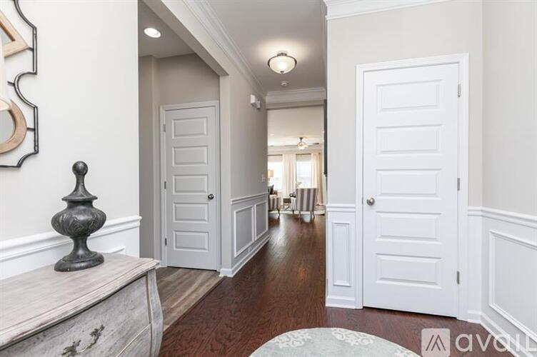 A hallway with white doors and a wooden floor.