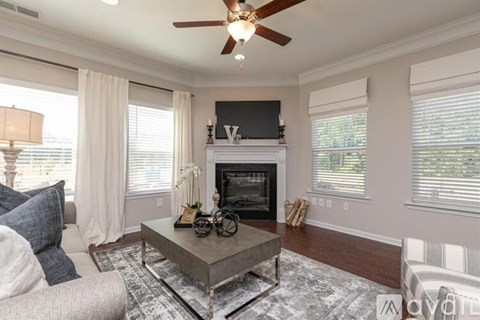 A living room with a fireplace and a television above it.