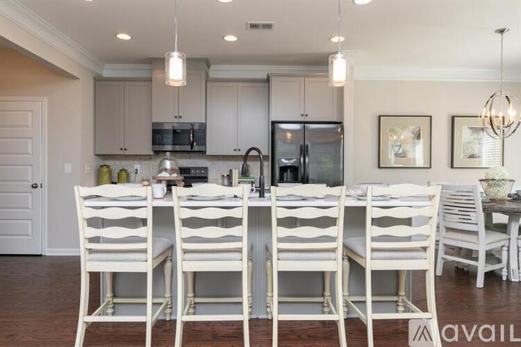 A kitchen with white chairs and a wooden table.