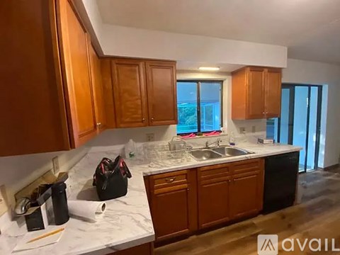A kitchen with wooden cabinets and a marble countertop.