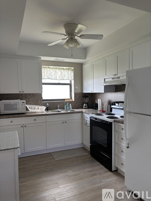 A kitchen with white cabinets and a black oven.