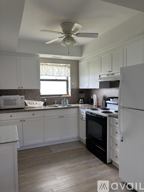 A kitchen with white cabinets and a black oven.