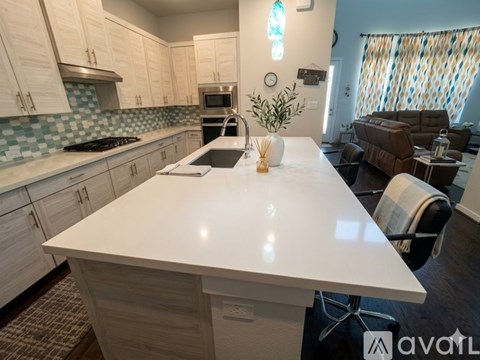 A kitchen with a white countertop and a stove top oven.