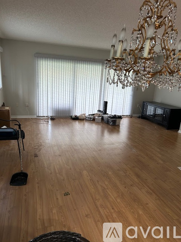 A large room with a chandelier and a piano.